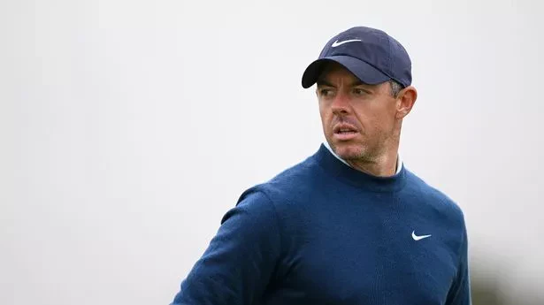 Rory McIlroy wearing navy Nike cap and sweater, looking serious.