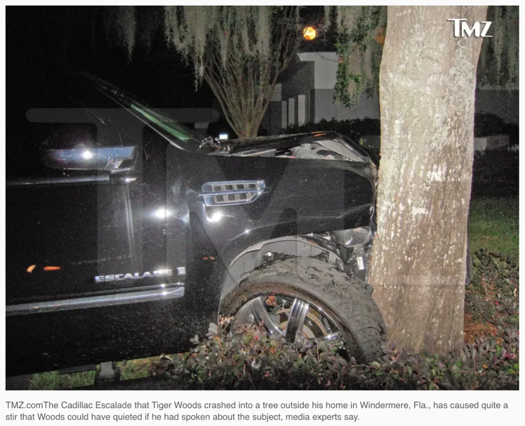 Damaged black Cadillac Escalade crashed into tree at night, TMZ watermark.