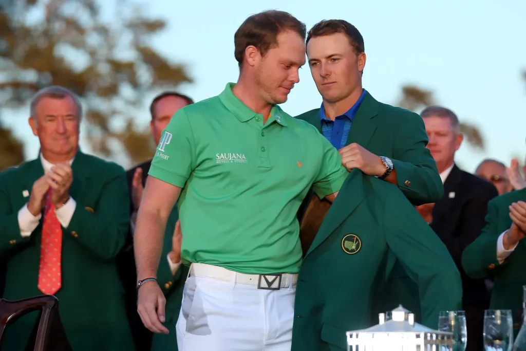 Jordan Spieth helps Danny Willett put on Masters green jacket during ceremony.