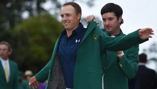 Bubba Watson helps Jordan Spieth put on Masters green jacket during ceremony.